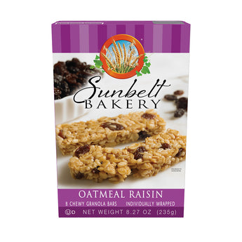 Box of Sunbelt Bakery Oatmeal Raisin Chewy Granola Bars with a purple stripe design at the top. The box front displays the chewy granola bars with raisins against a backdrop of scattered raisins. The Sunbelt Bakery logo with a wheat motif is prominently displayed. The box also reads '8 Chewy Granola Bars', 'Individually Wrapped', with a net weight of 8.27 oz (235g).