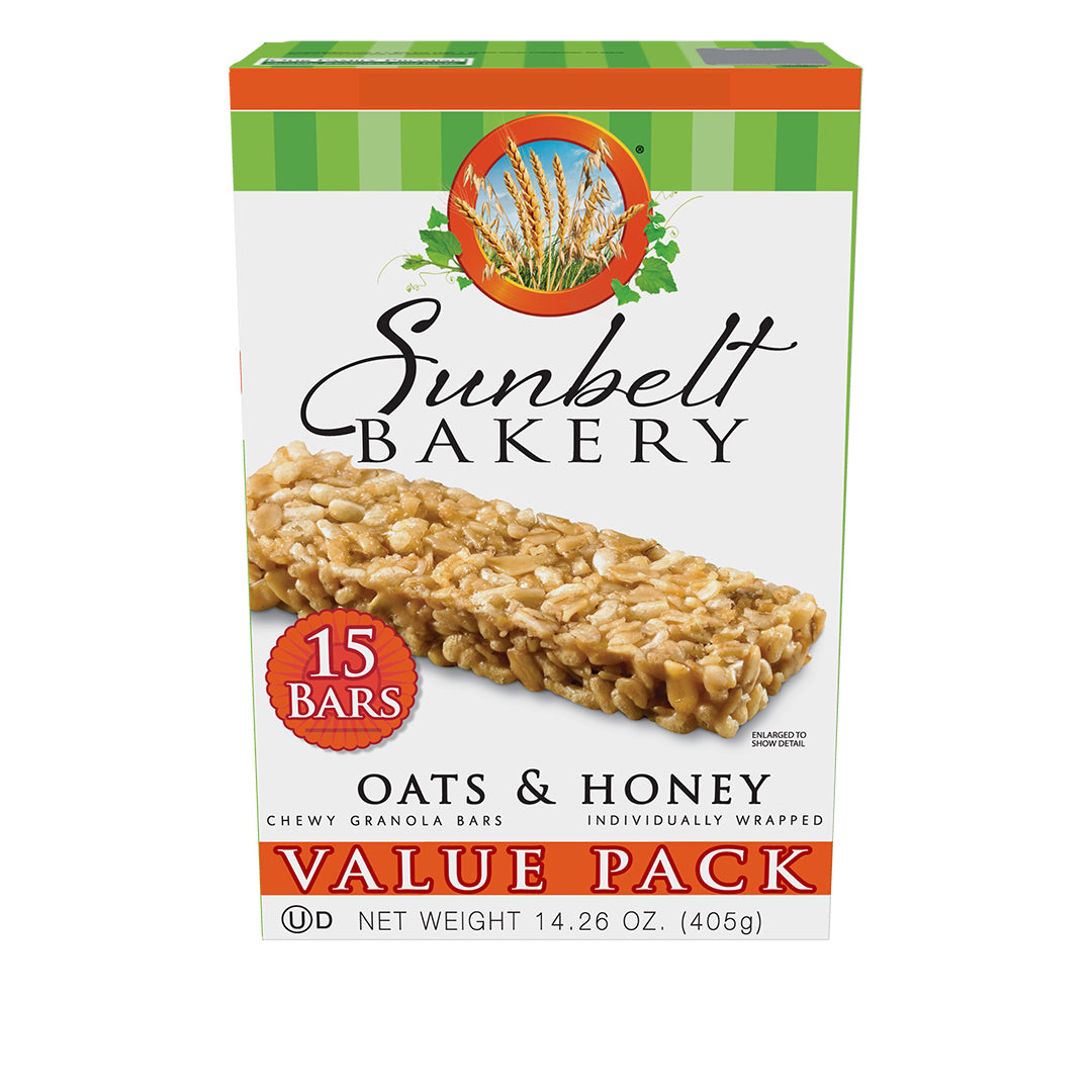 Value Pack box of Sunbelt Bakery Oats & Honey Chewy Granola Bars with green and orange stripes on the top. The packaging displays chewy granola granola and a '15 Bars' badge. The top features the Sunbelt Bakery logo set against a circular wheat field background. Labeled 'Value Pack', 'Individually Wrapped', the net weight is specified as 14.26 oz (405g).